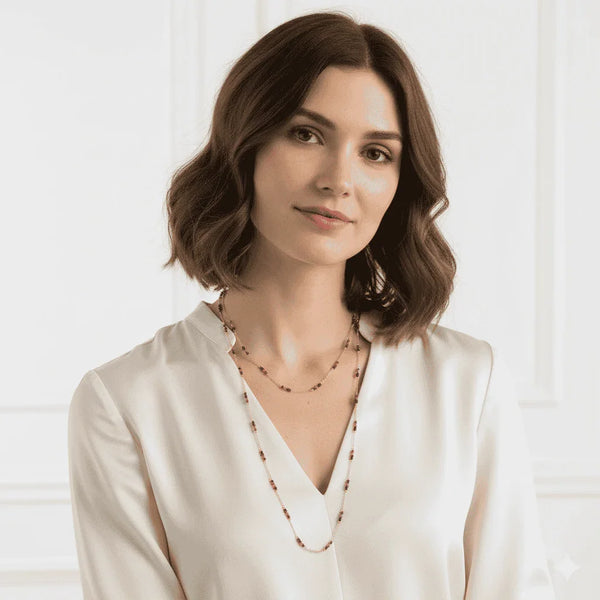 Woman wearing modern beaded necklace with white blouse, contemporary jewellery style